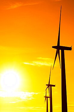 Commercial wind turbines at sunrise on a clear day