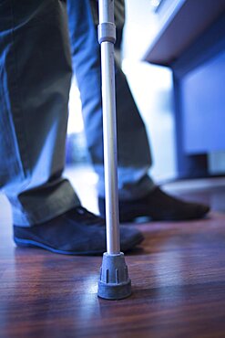 Man walking with crutch in hospital clinic photo.