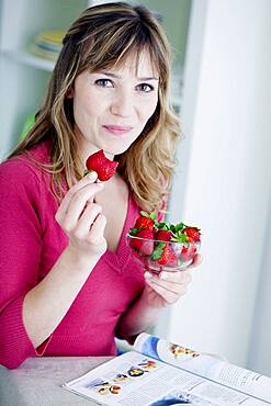 Woman eating strawberries.