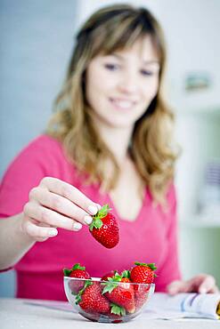 Woman eating strawberries.