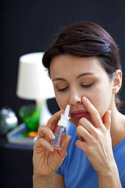 Woman using nose spray