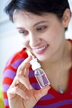 Woman using nose spray