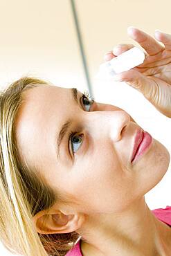 Woman using eye lotion