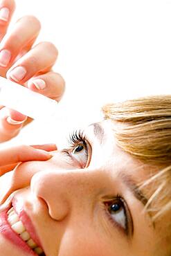 Woman using eye lotion