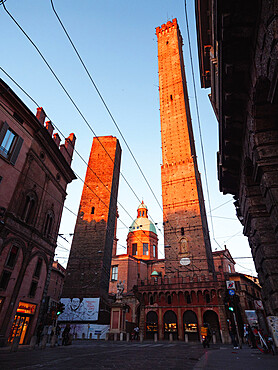 The Two Towers in Bologna at sunset being painted red by the sun, Bologna, Emilia Romagna, Italy, Europe