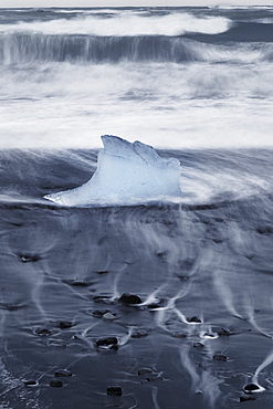 Iceberg or Growler shaped like a Glass Slipper on Fellsfjara Beach, nicknamed Diamond Beach, near Jokulsarlon, Southern Iceland, Europe