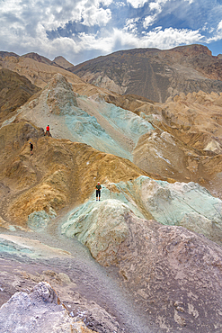 Tourists exploring colorful rocks at Artist's Palette, Death Valley National Park, Eastern California, California, USA