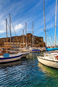 Small harbor with boats in front of the Castel dell'Ovo, Naples, Campania, Italy