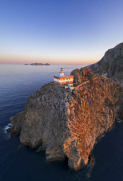 Panoramic aerial view of Ponza island lighthouse, Punta della Guardia, standing on top of a cliff facing the sea at dusk, Ponza island, Pontine islands, Mediterranean Sea, Latium, Lazio, Italy, Europe