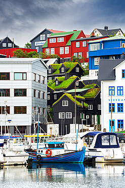 Old grass roof houses among new buildings and boats in the harbour of Torshavn, Streymoy island, Faroe Islands, Denmark, Europe