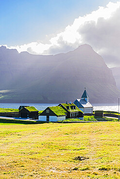 View of the church and grass roof houses in the village of Vidareidi at sunset, Vidoy island, Faroe Island, Denmark, Europe