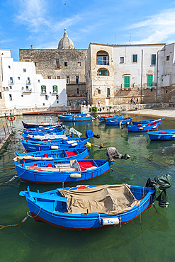 Rows of blue wooden boats in the water of the harbour of Monopoli old town, Monopoli, Bari province, Apulia, Italy, Europe