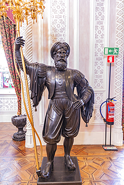 Europe, Portugal, Sintra. April 17, 2022. Sculpture of a Moor in the Park and National Palace of Pena, a UNESCO World Heritage Site in Sintra.