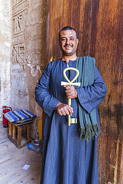 Abu Simbel, Aswan, Egypt. February 22, 2022. Caretaker holding a large key in the shape of an anhk at the Great Temple of Ramesses II.