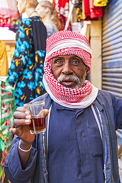 Thebes, Luxor, Egypt. February 24, 2022. Man in a keffiyeh drinking tea.