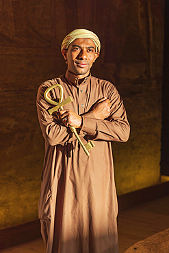 Abu Simbel, Aswan, Egypt. February 23, 2022. Caretaker holding a large key in the shape of an Ankh in the Great Temple of Ramesses II.