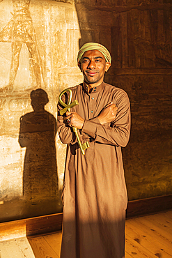 Abu Simbel, Aswan, Egypt. February 23, 2022. Caretaker holding a large key in the shape of an Ankh in the Great Temple of Ramesses II.