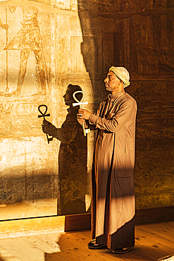 Abu Simbel, Aswan, Egypt. February 23, 2022. Caretaker holding a large key in the shape of an Ankh in the Great Temple of Ramesses II.