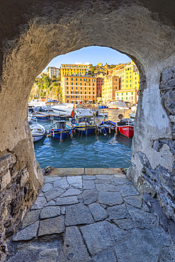 The beautiful harbour of Camogli seen through a house arch, Camogli, Genova province, Liguria, Italy, Europe