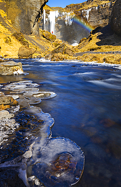 A person observes Kvernufoss waterfall and its gorge with rainbow, Skogar, Sudurland, Iceland, Polar Regions