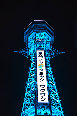 Osaka Tsutenkaku tower in the Shinsekai district. Illuminated blue night lights showing World Expo 2025. Japan