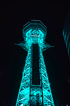 Osaka Tsutenkaku tower in the Shinsekai district. Illuminated turquoise night lights. Japan