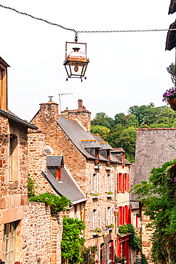 Narrow cobbled street with stone houses and lanterns in medieval town of Dinan Brittany France