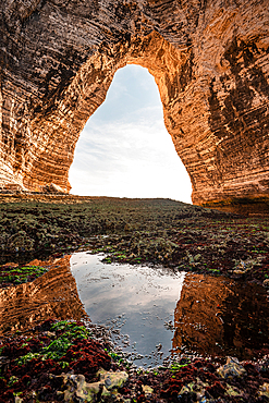 tical view of chalk cliff arch at Étretat Normandy with reflection in tidal pool