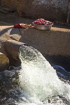 Washing out of the drain pumping water from the Nile to supply a crop irrigation channel around the village of Ramadi, west bank of the Nile south of Edfou, Egypt, North East Africa