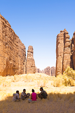 Sitting people meeting in front the magnificent sandstone rock structure in the Sharaan Nature Reserve, AlUla, Medina Province, Saudi Arabia, Middle East