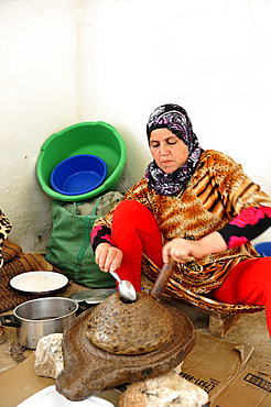 Woman grinding argan seeds to get oil,Saadia family,Tagante village,Anti-Atlas,Morocco,North Africa