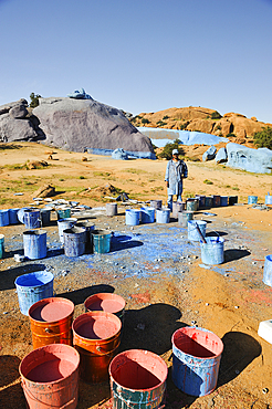 Painter working on Painting Rocks site, work of the Belgian artist Jean Verame. around Tafraout,Anti-Atlas,Morocco,North Africa