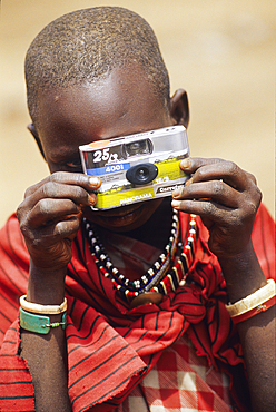 Maasai woman looking through a disposable camera, around the area of Namanga, Kenya, East Africa