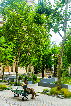 Soldier sitting in garden to commemorate terrorist actions on 13 November in front of church Saint-Gervais-Saint-Protais in day in summer