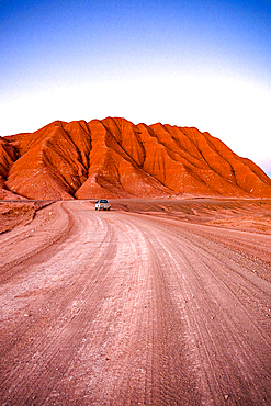 4x4 car driving among the red volcanic rocks and mountains in the Labyrinth Desert, Salta province, Puna, Argentina