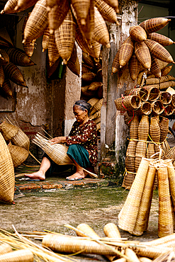 Senior woman weaving traditional bamboo fish traps, Hanoi, Vietnam. (MR)