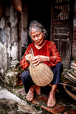Woman weaving handmade bamboo fish traps, Hanoi, Vietnam. (MR)