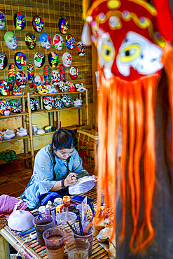 Woman painting a traditional mask, Hoi An, Quang Nam Province, Vietnam. (MR)