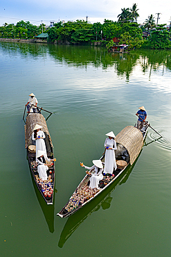 Women in traditional dress holding floating lanterns, Nhu Y River, Hue, Central Vietnam. (MR)