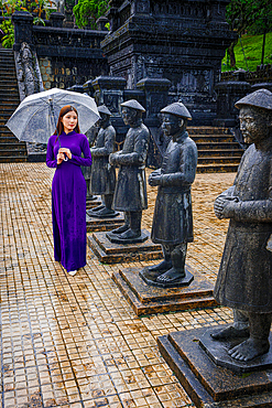 Woman in traditional ao dai looking at statues, Khai Dinh Mausoleum, Hue, Vietnam. (MR)