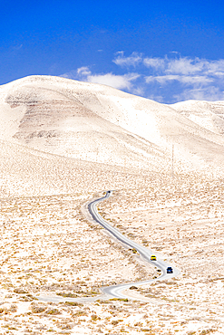 High angle view of cars driving on a winding desert road in the barren landscape, Jandia, Fuerteventura, Canary Islands, Spain