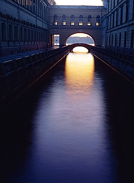 Dusk light reflected on the Winter Canal, through arch and bridge, St. Petersburg, Russia, Europe