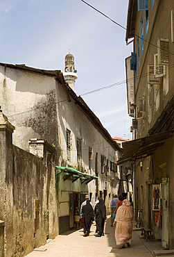 A busy street with a mosque minaret above in Stone Town, Zanzibar, Tanzania, East Africa, Africa