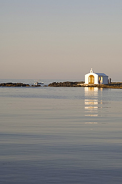 A small white washed church at the end of a quay in the village Yeoryioupolis near Hania on the north coast of Crete, Greece, Europe