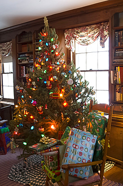 A Christmas tree decorated with lights and ornaments surrounded by gifts on Christmas morning, United States of America, North America