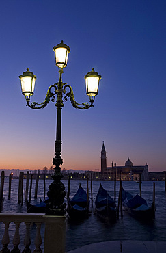 Gondolas at sunrise and San Giorgio Maggiore in silhouette in the background, Venice, UNESCO World Heritage Site, Veneto, Italy, Europe