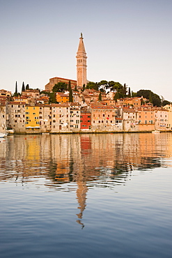 The Cathedral of St. Euphemia and Venetian style buildings in Rovinj reflected in the sea at sunrise, Rovinj, Istria, Croatia, Europe