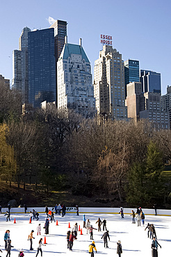 Skaters on the Woolman Rink in Central Park with the skyline behind, New York City, New York State, United States of America, North America