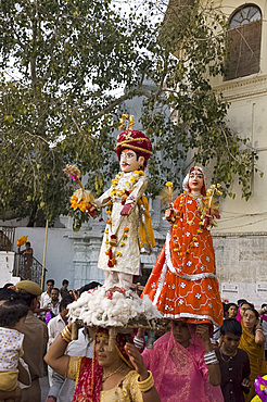 Sari clad women carrying idols at the Mewar Festival in Udaipur, Rajasthan, India, Asia