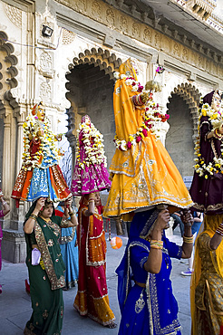 Sari clad women carrying idols at the Mewar Festival in Udaipur, Rajasthan, India, Asia